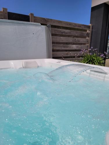 d'un bain à remous avec de l'eau bleue dans la cour. dans l'établissement Havre de détente plage et jacuzzi, à Cléder