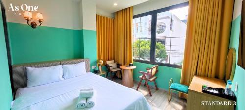 a bedroom with a bed and a large window at As ONE Hotel Biên Hòa in Bien Hoa