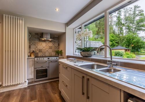 eine Küche mit einem Waschbecken und einem großen Fenster in der Unterkunft The Mill at Marrington Estate in Chirbury