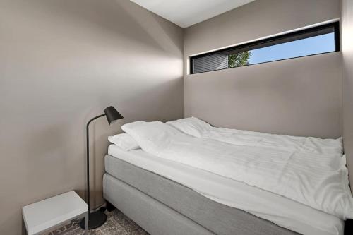 a bedroom with a white bed and a window at Seaview studio w/terrace&parking in Tromsø