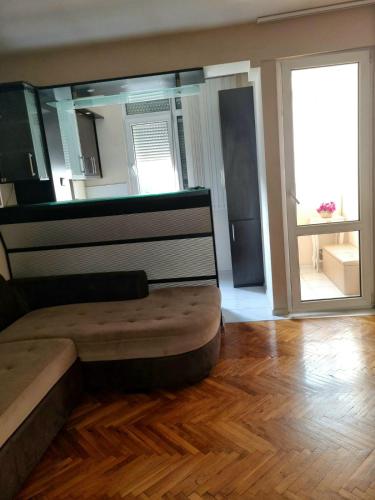 a room with a bed and a wooden floor at Teodora Apartment in Ruse