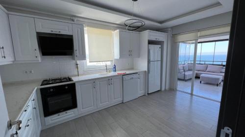 a kitchen with white cabinets and a view of the ocean at Site içerisinde deniz manzaralı ve sahile yakın otopark sorunu bulunmayan kiralık daire in Fatsa
