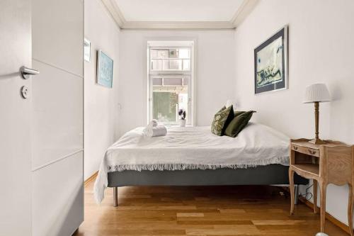 a white bedroom with a bed and a window at Dinbnb Apartments I Characteristic Townhouse with Bathtub in Bergen