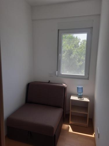 a small room with a couch and a window at Nino Lux Apartments Ulcinj in Ulcinj