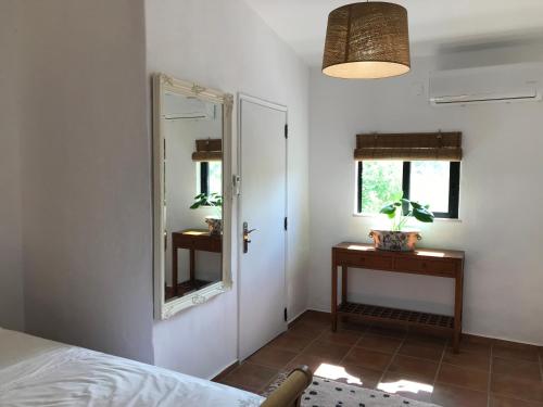 een slaapkamer met een bed, een spiegel en een tafel bij Casa tranquil in Santa Bárbara de Nexe