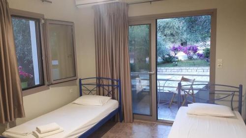 2 Betten in einem Zimmer mit Blick auf einen Innenhof in der Unterkunft Sivota apartments Parthenia in Syvota