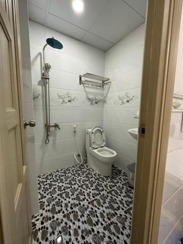 La salle de bains est pourvue de toilettes et d'un sol noir et blanc. dans l'établissement Hotel Trang Huy, à Thuan An