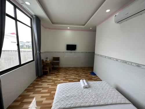 a room with a bed and a tv in it at Hotel Trang Huy in Thuan An