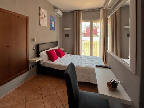 a small bedroom with a bed with red pillows at Tiè tiè in Naples