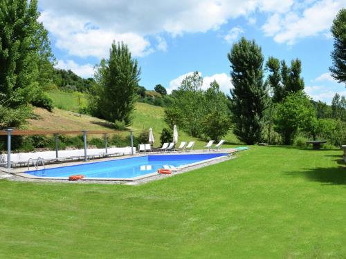 a swimming pool in a grassy yard with lounge chairs at Farmhouse in Castelfranco Piandisc with Garden in Castelfranco di Sopra