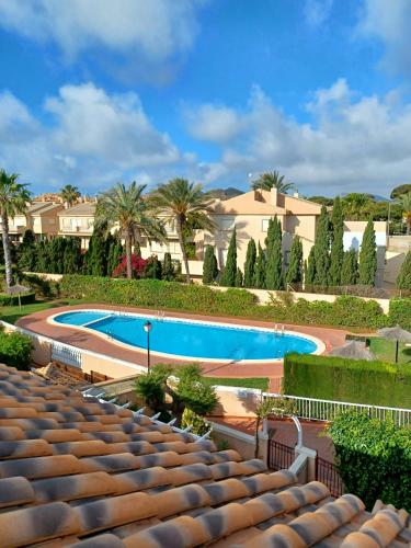 a large swimming pool with palm trees and buildings at Bonita casa en pueblo pictórico, Ideal para familias, grupos y Buceadores in Cabo de Palos