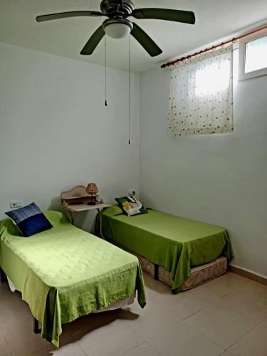 a bedroom with two beds and a ceiling fan at Bonita casa en pueblo pictórico, Ideal para familias, grupos y Buceadores in Cabo de Palos