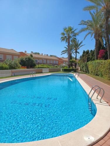 a swimming pool in a resort with palm trees at Bonita casa en pueblo pictórico, Ideal para familias, grupos y Buceadores in Cabo de Palos