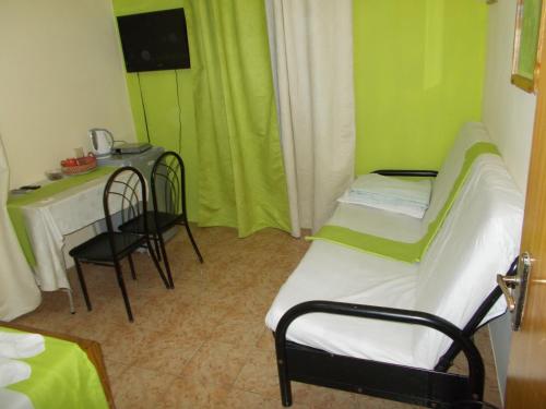 a room with two beds and a table and a table and chairs at Residence Les Bambous in Mahébourg