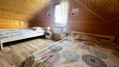 ヤロスワビエツにあるKolorowe Domkiの木造キャビン内のベッド1台が備わるベッドルーム1室を利用します。