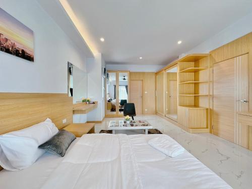 a bedroom with a large white bed and a desk at Rosewood Pool Villa Pattaya 3 in Pattaya South