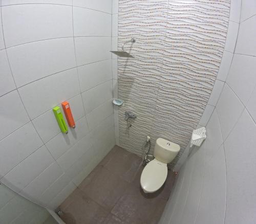 La salle de bains blanche est pourvue d'une douche et de toilettes. dans l'établissement Mendiro Griya Syariah, à Ngemplak