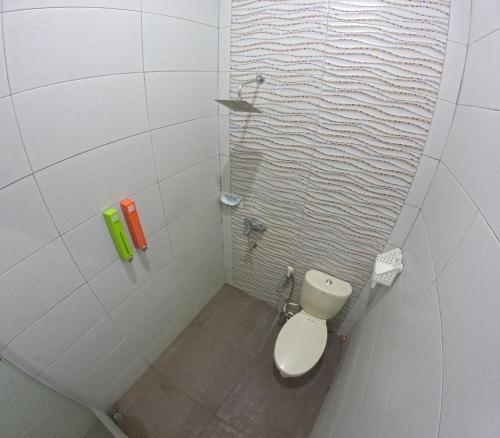 a white bathroom with a toilet in a shower at Mendiro Griya Syariah in Ngemplak