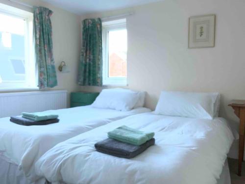 a bedroom with two beds with towels on them at Ivy cottage in West Mersea