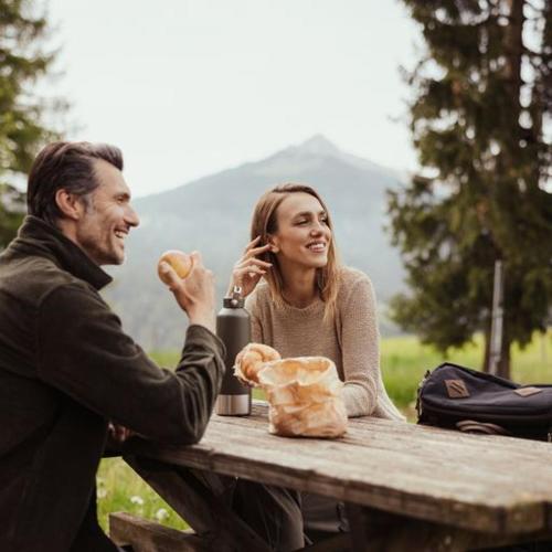 a man and a woman sitting at a picnic table at Hotel Leonhard in Nova Ponente