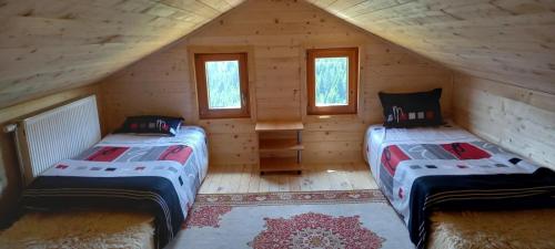 a bedroom with two beds in a log cabin at Daci Guesthouse 