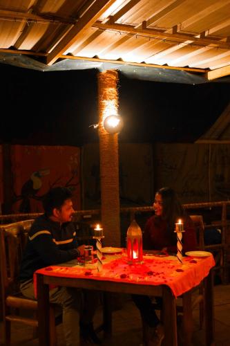 a man and woman sitting at a table with candles at Nature Zone Jungle Resort in Munnar