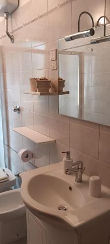 a bathroom with a sink and a mirror and a toilet at Santa Margherita Ligure Apartment with parking in Santa Margherita Ligure