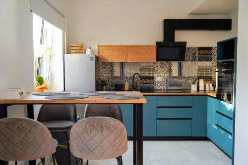 a kitchen with blue cabinets and a table with stools at Stunning new apartment in centre of Buzet in Buzet