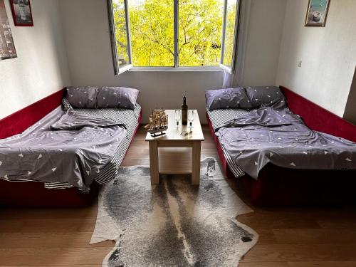 Zimmer mit 2 Betten und einem Tisch in der Unterkunft Apartment Ollie Tuzla in Tuzla