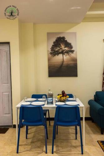a dining room with a table and chairs and a tree at The Banyan Tree Adobe in Kolhapur