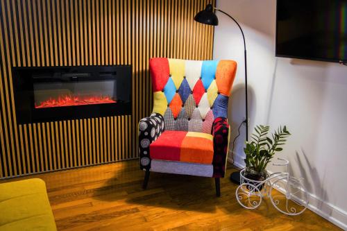 a colorful chair in a living room with a fireplace at Stunning new apartment in centre of Buzet in Buzet