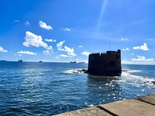 Una roccia nell'acqua con le navi nell'oceano di Casa La Calma a Las Palmas de Gran Canaria