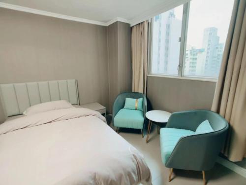 una camera da letto con due sedie e un letto e una finestra di 皇后超級管家 a Hong Kong