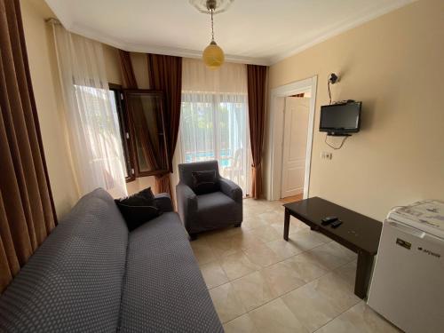 uma sala de estar com um sofá e uma cadeira em Tulip Apart Hotel em Ortaca