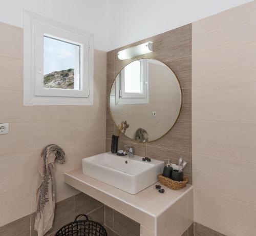 a bathroom with a white sink and a mirror at Kanelis on the hill in Mytakas
