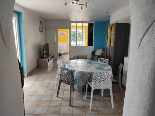 a dining room table and chairs in a room at Maison de vacances La Quercynoise in Flaujac-Poujols