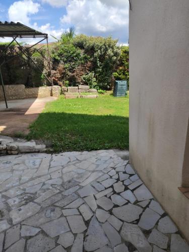 a corner of a building with a yard with grass at Maison de vacances La Quercynoise in Flaujac-Poujols
