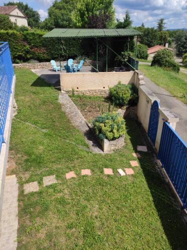 a backyard with a fence and a yard with plants at Maison de vacances La Quercynoise in Flaujac-Poujols