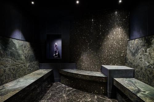 a room with two benches and a stone wall at Kimpton Blythswood Square Hotel & Spa by IHG in Glasgow