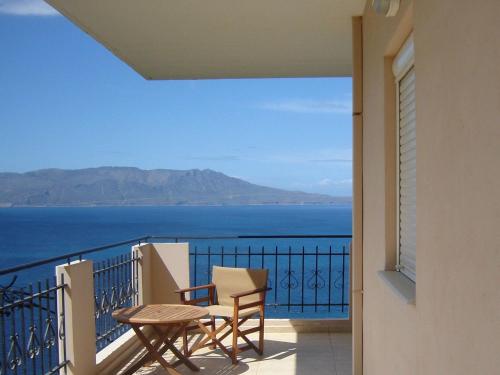 balcón con mesa, sillas y vistas al océano en Seaview Studio in beautiful setting west from Chania, en Ravdhoúkha
