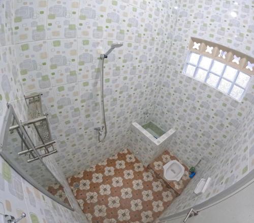 ein kleines Bad mit einer Dusche und einem WC in der Unterkunft Griyo Mondoliko Homestay Jogja in Demangan