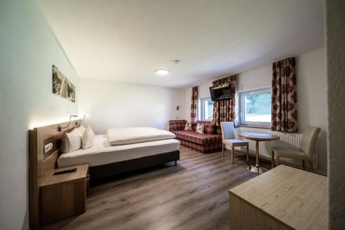 ペットイ・アム・アールベルクにあるAppartements Tyrolのベッドとリビングルームが備わるホテルルームです。