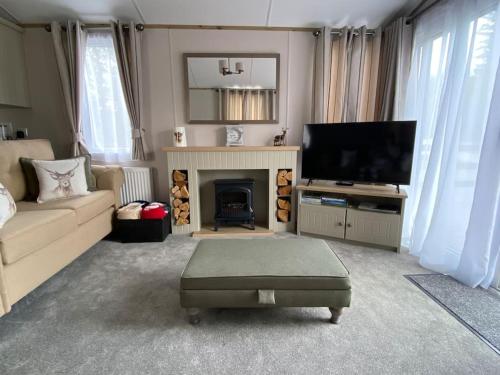 a living room with a fireplace and a television at Perfect for country lovers in Grantown on Spey