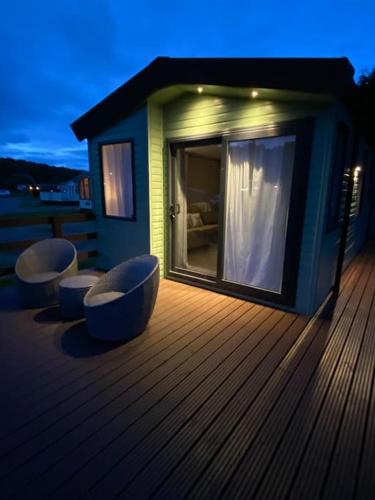 a house on a deck with two chairs on it at Perfect for country lovers in Grantown on Spey