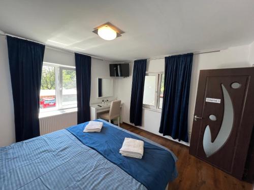 sypialnia z niebieskim łóżkiem i 2 ręcznikami w obiekcie Accommodation Casa Luca w mieście Horezu