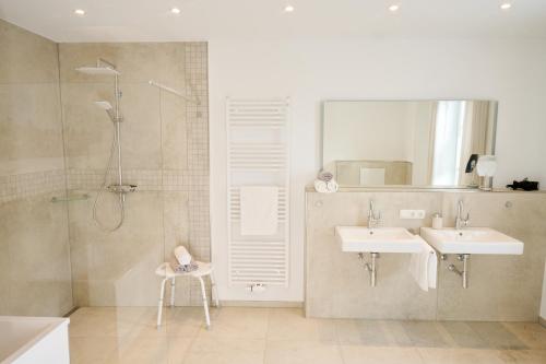 ein Bad mit einer Dusche, 2 Waschbecken und einer Dusche in der Unterkunft Landhaus Eichengarten in Soltau