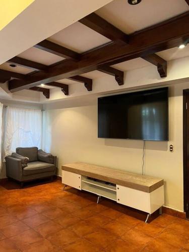 a living room with a flat screen tv and a couch at Casa dentro del Campo de Golf in Comayagua