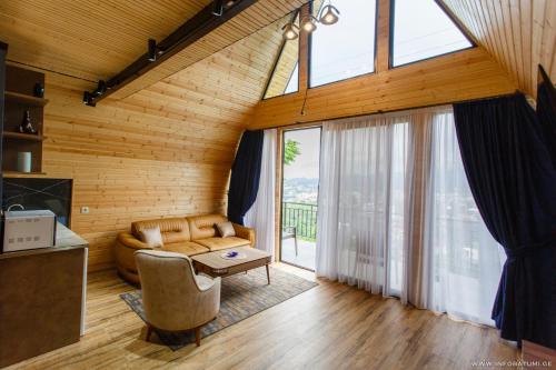 ein Wohnzimmer mit einem Sofa und einem großen Fenster in der Unterkunft Panorama BatumGora in Batumi