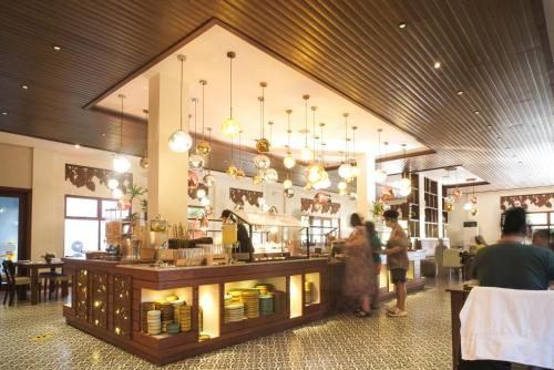 ein Restaurant mit Leuten, die um eine Essenstheke stehen in der Unterkunft La Jolla Hotel and Beach Resort in Malawin