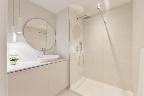 une salle de bain avec une douche, un lavabo et un miroir dans l'établissement Luna mia 500 m du lac, à Annecy